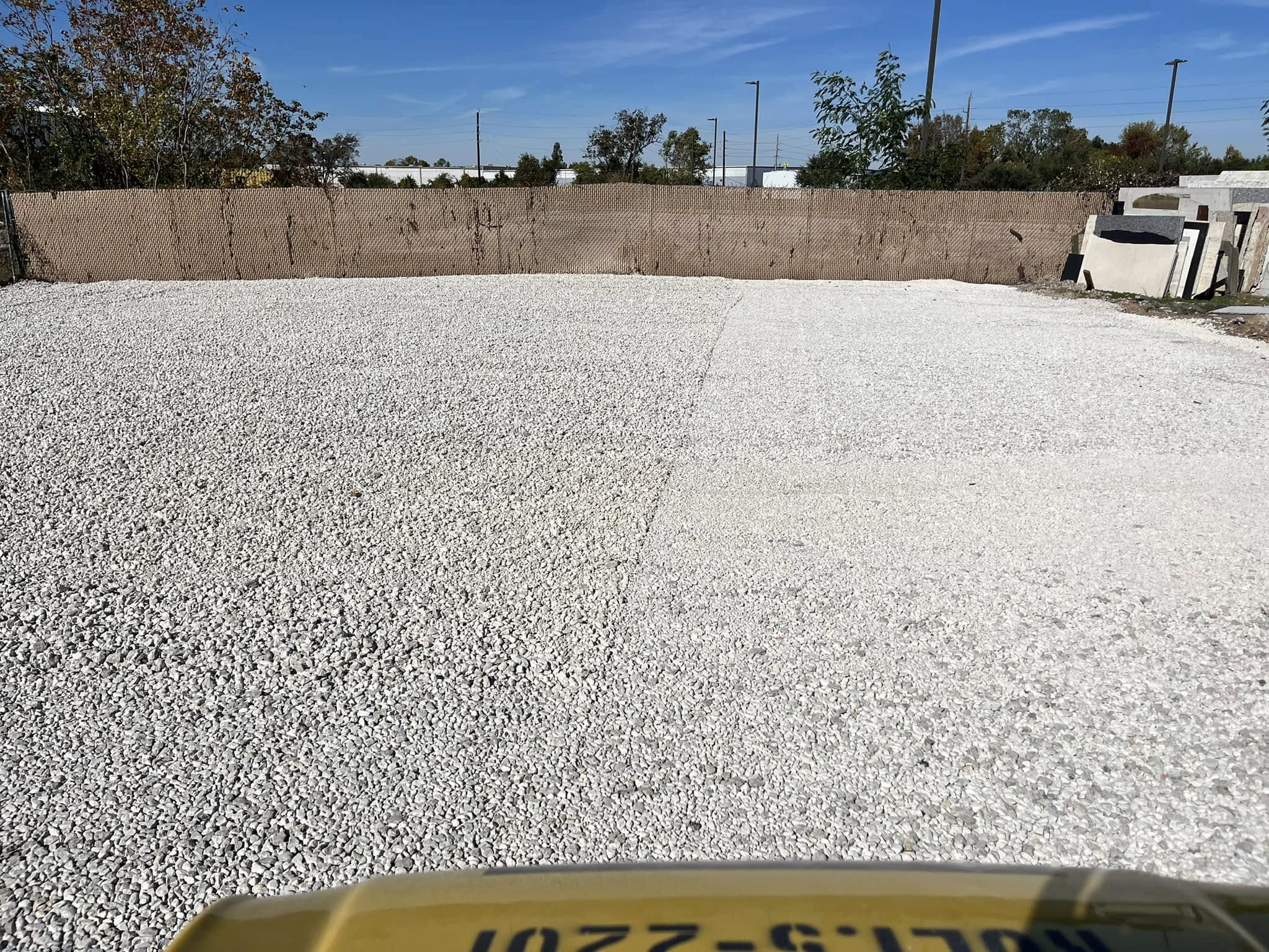 Large gravel yard being smoothed out with drum roller