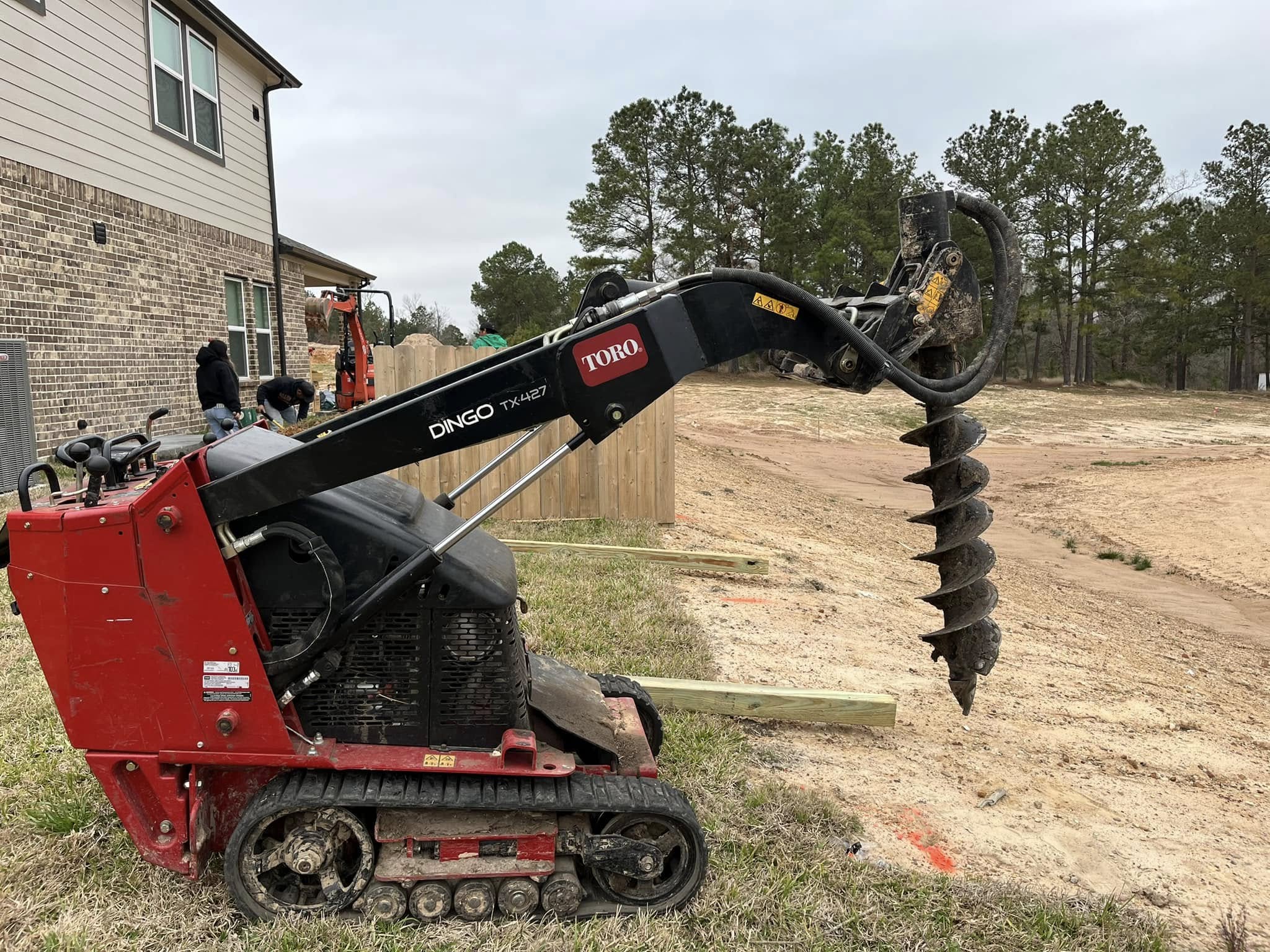 Auger hole driller about to drill a hole for a fence line